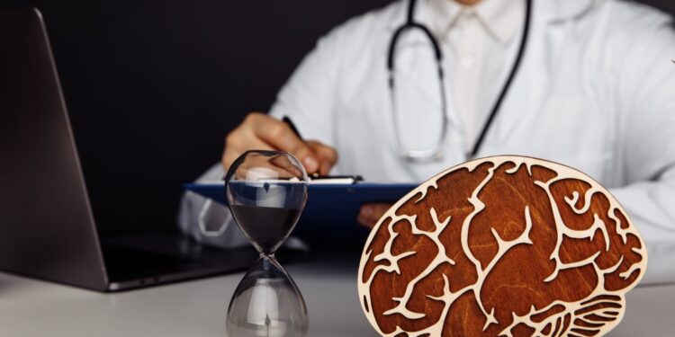 Wooden brain and hourglass in doctor's office. The importance of early diagnosis concept.